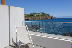 a white chair sitting on a balcony looking out at the ocean at GuestReady - Tranquil Oasis in Lagoa in Lagoa