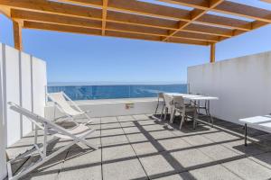 a balcony with chairs and a table on a roof at GuestReady - Tranquil Oasis in Lagoa in Lagoa