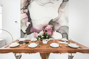a wooden table with white plates and flowers on top at Rooftop Condo in Nashville