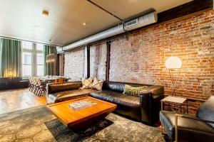 a living room with leather couches and a brick wall at Tasteful Loft in Nashville