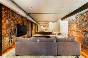 a living room with a couch and a brick wall at Tasteful Loft in Nashville