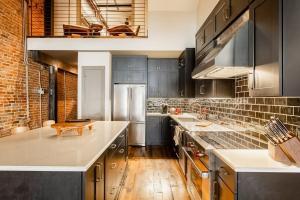a kitchen with black cabinets and stainless steel appliances at Tasteful Loft in Nashville