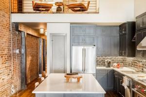a kitchen with blue cabinets and a white refrigerator at Tasteful Loft in Nashville +36 photos