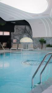 a large swimming pool with chairs and an umbrella at Motel Predejane in Predejane