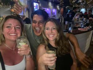 a man and two women holding drinks in a bar at Backpackers Homestay 21-36 yrs ONLY in Caloundra