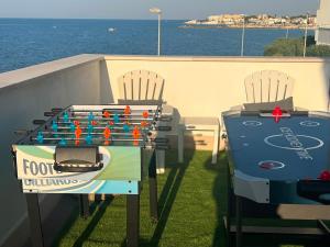 a table and chairs on a balcony with a table and a game at Palese Profumo di Mare in Santo Spirito