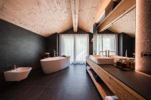 a large bathroom with two sinks and two tubs at AlpeLuce Mountain Chalet in Arabba +40 photos