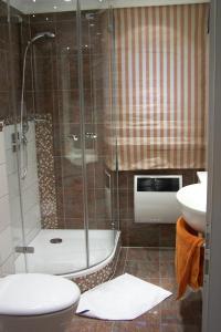 ein Bad mit einer Dusche, einem WC und einem Waschbecken in der Unterkunft Marina 38-2 in Cuxhaven