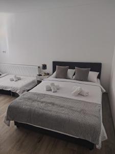 a bedroom with two beds with white towels on them at Apartmani Hilston in Vršac