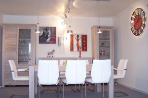 a dining room with a table and white chairs at Marina 38-2 in Cuxhaven