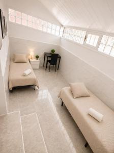 a attic room with two beds and a table at Little Los Emilios in Torrevieja