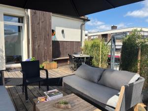 a patio with a couch and a table on a deck at Hotel Zur Krone in Nordwalde