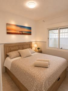 a bedroom with a large bed with a large window at Little Los Emilios in Torrevieja
