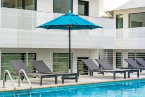 a group of chairs and an umbrella next to a pool at Illume 407 in Nashville