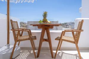 a table with a pineapple on it with two chairs at GuVer Luxury Suites in Agia Anna Naxos