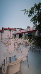 a row of chairs and tables and tables and chairs at Motel Predejane in Predejane