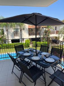 a blue table with chairs and an umbrella at Oroklini by the pool in Oroklini