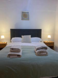 a bedroom with a large bed with towels on it at Casa Ckunna in San Pedro de Atacama