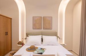 a bed with two pillows and a hat on it at GuVer Luxury Suites in Agia Anna Naxos