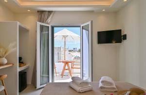 a bedroom with an open door to a patio with an umbrella at GuVer Luxury Suites in Agia Anna Naxos