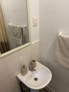 a white bathroom with a sink and a mirror at Casa Ckunna in San Pedro de Atacama