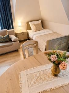 ein Zimmer mit zwei Betten und einem Tisch mit Blumen darauf in der Unterkunft Dom Noemi in Płock