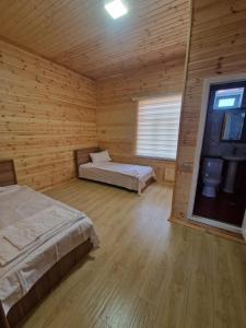 a room with two beds in a wooden cabin at Brick Villas in Qusar