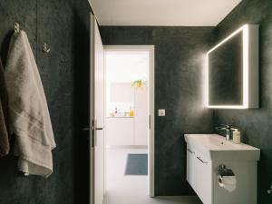 a bathroom with a sink and a toilet and a window at Apartment Baytrail in See- und Bergnähe, modern, mit Garten, 4 Gäste in Spiez +78 photos