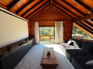 a living room with a couch and a large screen at Cabanha Tessaro in Chapecó