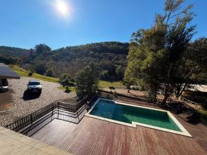 a swimming pool with a car parked in a yard at Cabanha Tessaro in Chapecó