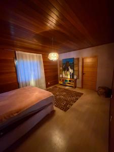 a bedroom with a bed and a chandelier at Cabanha Tessaro in Chapecó +30 photos