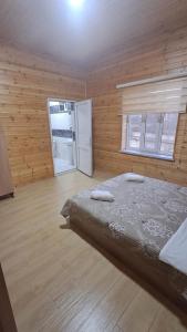a bedroom with a bed in a wooden room at Brick Villas in Qusar