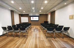 a conference room with black chairs and a screen at El Portal Del Marques in Cajamarca