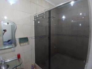 a shower with a glass door in a bathroom at Casa aconchegante in Manaus +8 photos