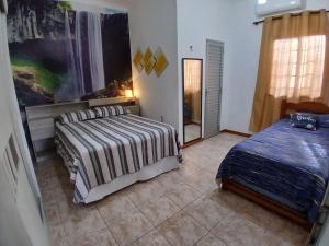 a bedroom with two beds and a window at Casa aconchegante in Manaus