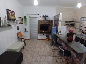 a living room with a kitchen with a counter top at Casa aconchegante in Manaus