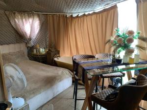 a bedroom with a bed and a table with chairs at Couple Baltic Coast Retreat in Apšuciems