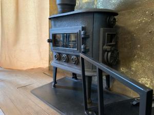 an old stove with a microwave in a room at Couple Baltic Coast Retreat in Apšuciems +5 photos