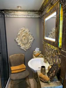 a bathroom with a sink and a chair and a mirror at Couple Baltic Coast Retreat in Apšuciems