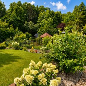 ein Garten mit Blumen und Bäumen im Hintergrund in der Unterkunft Dom Noemi in Płock