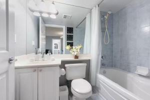 a bathroom with a toilet and a sink and a tub at Designer Apartment in Prime Location in Mississauga +71 photos