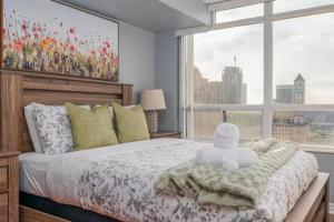 a bedroom with a bed and a large window at Designer Apartment in Prime Location in Mississauga