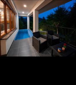 a patio with two chairs and a swimming pool at Kuća za odmor - Villa Magdalena in Otočac