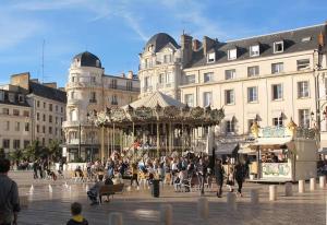 a group of people walking around a city with a carousel at Studio Terrasse - Parking gratuit in Orléans