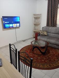 a living room with a table and a couch at Cosy appartement à Nongo in Conakry