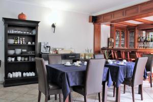 a dining room with a blue table and chairs at President Lodge in Edenvale