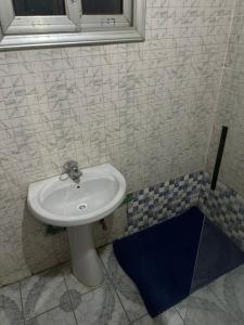 a bathroom with a white sink and a mirror at Cosy appartement à Nongo in Conakry +21 photos