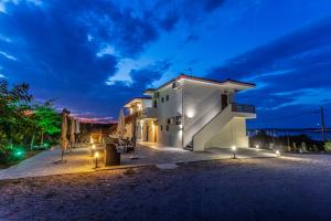 a white building with lights on the side of it at seaandolive in Ammouliani