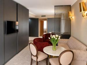 a living room with a couch and a table and chairs at Hotel Carpathia in Sinaia