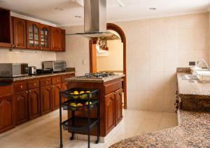 a kitchen with wooden cabinets and a basket of fruit at Paisa Hostel Medellín in Medellín